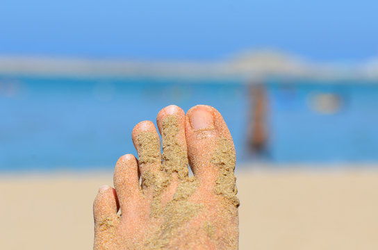 close up of sandy feet on beach