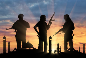 Silhouette of armed men attacking mosque during sunset
