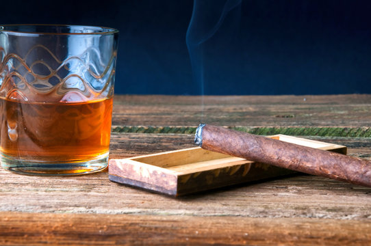 Whisky and cigar on wooden table