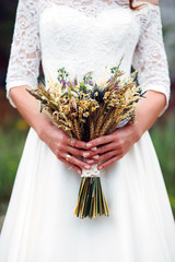 bouquet dried flowers in hands of bride