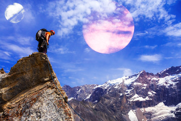 Alpine Climber staying on rocky Cliff with Planets in Sky