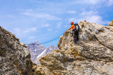 Mountain Climber on rocky ridge with rope and safety gear