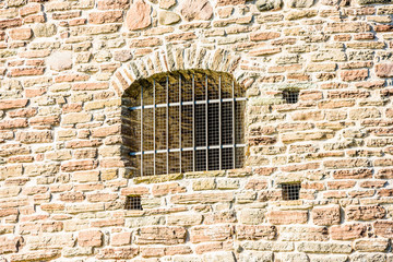 Barred prison windows on a castle or fortification.
