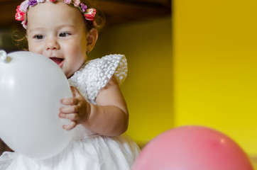 baby playing with balloons at home