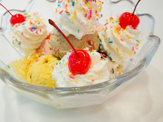Ice cream scoops with whipped cream and cherry