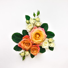 Decorative composition of orange and white roses, green leaves on white background. Flat lay, top view