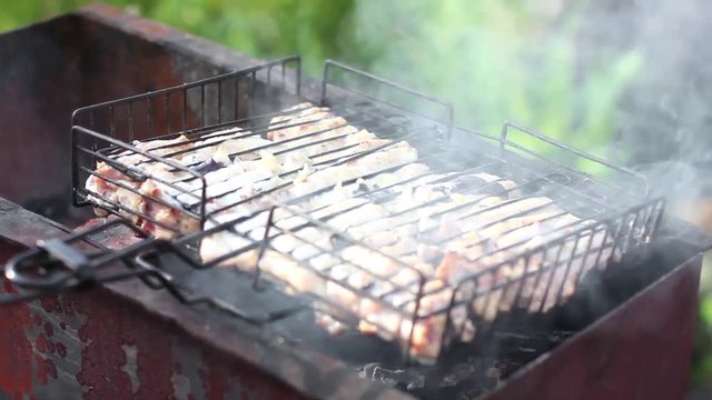 Shish kebab is prepared on the grill in smoke