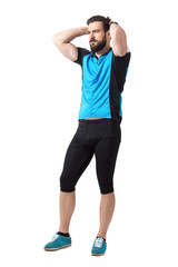 Unhappy facial expression of young male cyclist with hands on head.  Full body length portrait isolated over white studio background.