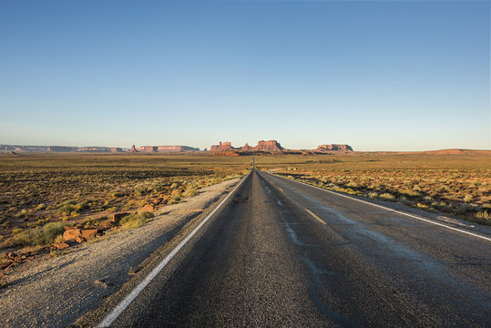 View of Monument Valley canyons during sunrise with Road in Arizona