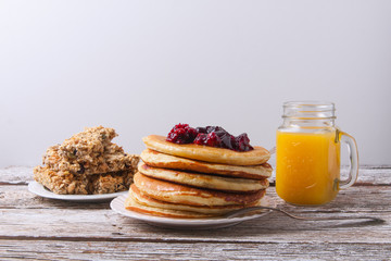 Stack of pancakes with glass of orange juice