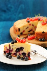 Traditional homemade cake with currants and blueberries on blue background