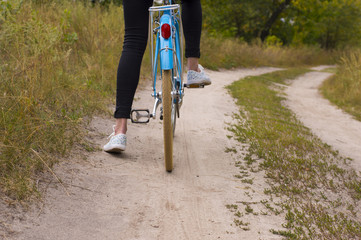 Close up of Young Woman Riding Vintage Bicycle in Forest