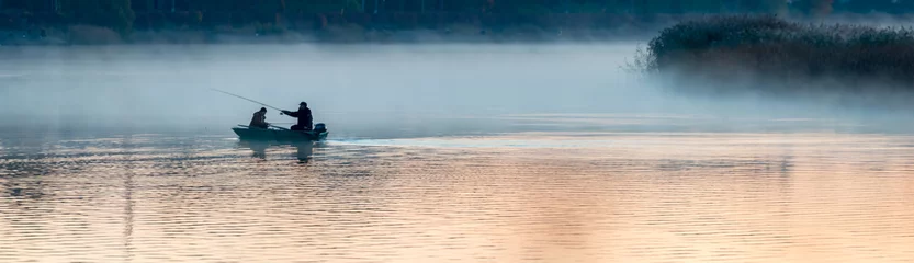 Selbstklebende Fototapete Fluss Fischer an einem Fluss am frühen Morgen