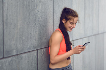 Sportliche junge Frau schreibt auf dem Smartphone