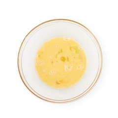 Whisked eggs in a glass bowl isolated