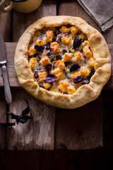 Galette with cheese on wooden table.
