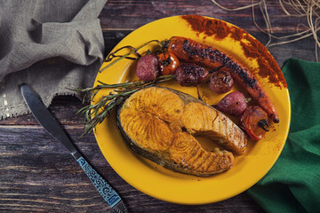 Baked salmon steak with stir-fry veggies. Viewed from above.