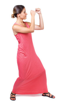 skinny woman funny fights waving his arms and legs. Isolated over white background. A slender woman in a long red dress in boxing pose.