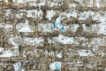 Texture of old brick wall with scraps of burnt paper on it