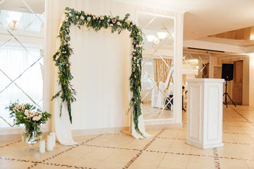 white wedding arch decorated with flower indoor