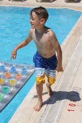 A young boy playing in a swimming pool while on vacation, 2016
