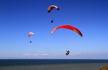 Gleitschirmflieger am Meer vor blauen Himmel