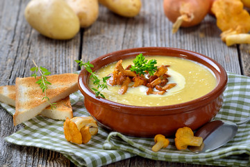 Cremige Kartoffelsuppe mit frischen Pfifferlingen und Creme fraiche - Cream of potato soup with...