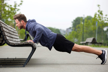 Attractive man doing pushup outside