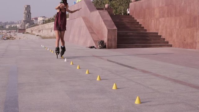 Young Beautiful Girl Rollerblading In A Park.