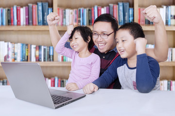 Obraz premium Kids and teacher raise hands in library