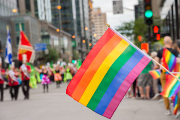 Gay rainbow flags at Montreal gay pride parade with blurred spectators in background