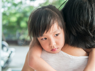 Asian baby girl hugging her mother , sleepy