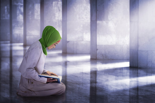Young asian muslim woman reading the koran