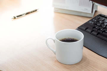 A white cup of coffee on the desk