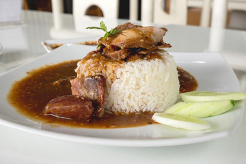 Red pork on jasmin rice with sweet sauce on white plate