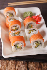 Sushi rolls Philadelphia with salmon and chopsticks close-up. Vertical 
