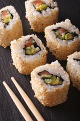 California roll with salmon in sesame macro. Vertical

