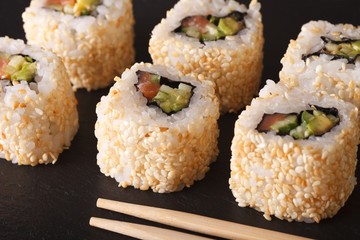 California roll with salmon in sesame macro. Horizontal
