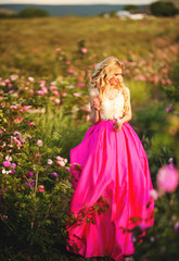 Obraz na płótnie Canvas beautiful girl in a field of roses