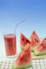 Watermelon juice and slices of watermelon.