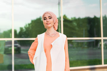 Young woman wearing hijab head scarf in city.