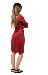 back view of standing young beautiful  woman.  girl  watching. Rear view people collection.  backside view of person. The girl in red plaid dress standing sideways with his arms crossed.  