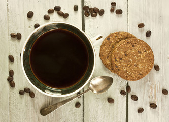Black coffee with oatmeal cookies, with coffee grains scattered