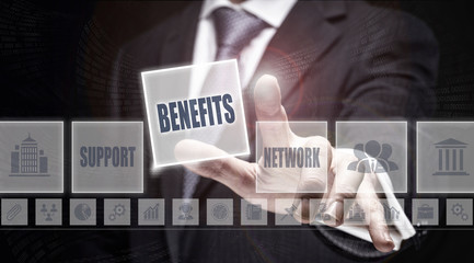 Businessman pressing an Benefits concept button on a dark background