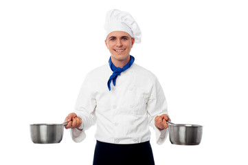 Chef posing with saucepans.