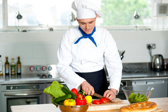 Preparing food: chef cutting tomato