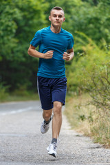 Boy jogging through forest