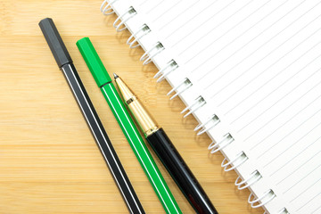 stationery and paper notebook on wooden background