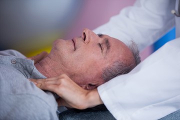 Obraz na płótnie Canvas Senior man receiving shoulder massage from physiotherapist