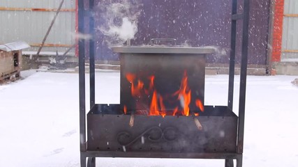 Metal smoker box standing on fire
